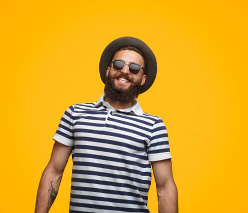 smiling man in front of yellow wall